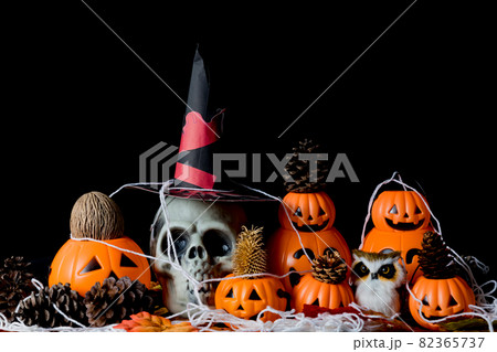 Halloween human skull, Halloween Pumpkins on an old wooden table in front of black background with free space for text. 82365737