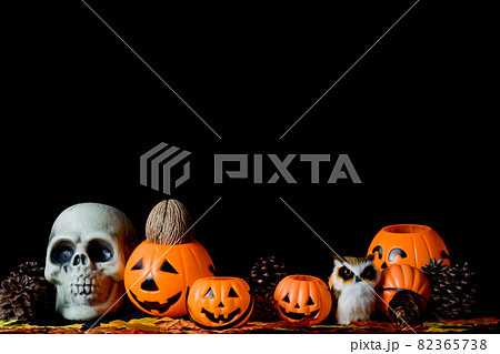 Halloween human skull, Halloween Pumpkins on an old wooden table in front of black background with free space for text. 82365738