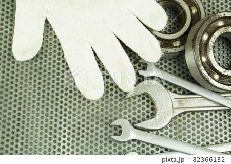 Replacement of the bearing, steel parts, a wrench, on the background of a metal grid. Repair of equipment. Replacement of the bearing, steel parts, a wrench, on the background of a metal grid. Repair of equipment. 82366132