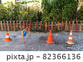 Three different traffic cones are blocking path to someone's garden with fence at private property. Cone with white and red stripes is used as warning sign on construction site and places of danger 82366136