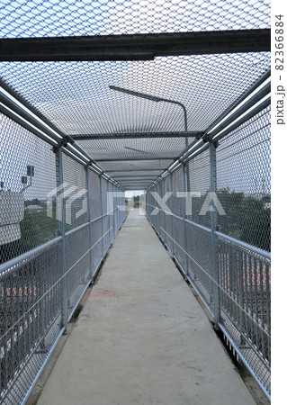 Under Metal mesh on steel walkways or Caged in walk way over passing highway and railway. 82366884
