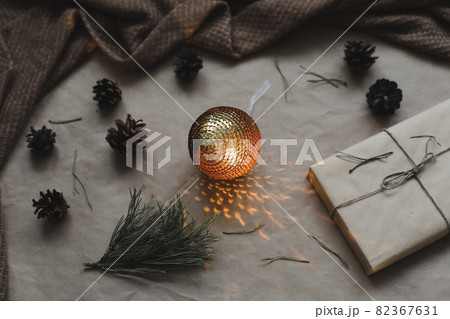 Christmas composition. Gift, fir tree branches, balls on craft paper background. Christmas, winter, new year concept. Flat lay, top view, copy space 82367631
