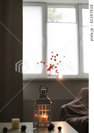 cozy autumn still life, candles, flowers, twigs of orange physalis in a vase and details of home interior 82367638