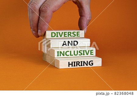 Diverse and inclusive hiring symbol. Wooden blocks with words Diverse and inclusive hiring on beautiful orange background. Businessman hand. Business, HR, diverse inclusive hiring concept. Copy space. Diverse and inclusive hiring symbol. Wooden blocks with words Diverse and inclusive hiring on beautiful orange background. Businessman hand. Business, HR, diverse inclusive hiring concept. Copy space. 82368048