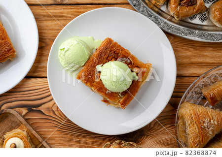 Turkish dessert kunefe served with ice cream on wooden background 82368874