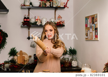 Portrait of smiling young housewife in modern kitchen 82369101