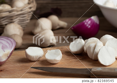 Cooking edible puffball mushrooms. Cutting peeled mushrooms on a cutting board, closeup Cooking edible puffball mushrooms. Cutting peeled mushrooms on a cutting board, closeup 82369545
