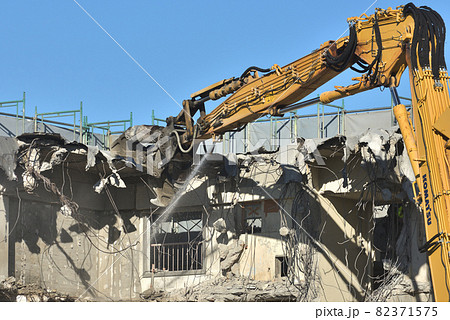 取り壊される老築化した公営住宅 大型重機で解体の作業風景の写真素材