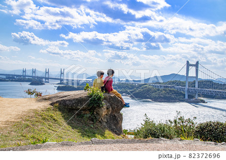 仲良く座って瀬戸内海と瀬戸大橋を眺める兄弟　岡山県倉敷市 82372696