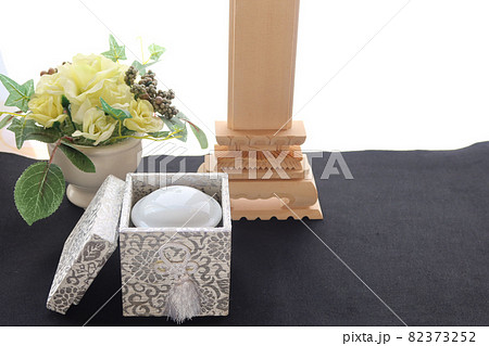 手元供養の骨壺とフラワーアレンジメント。コピースペース 82373252