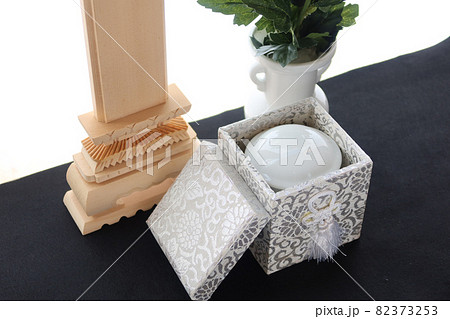 手元供養の骨壺と仏花 82373253