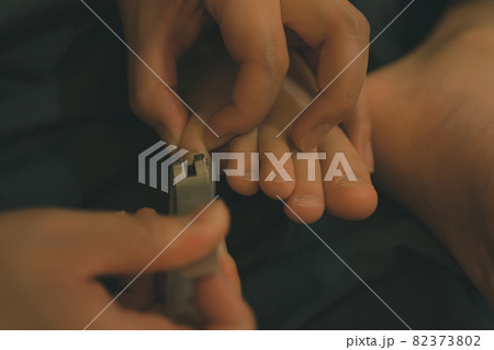 子供の足の爪を切る母親 82373802