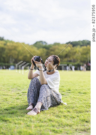 公園で写真を撮るカメラ女子 82375956