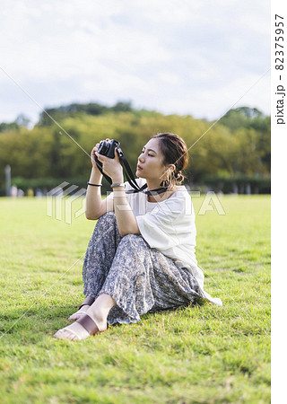 公園で写真を撮るカメラ女子 82375957