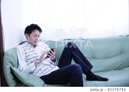休日にソファーでくつろぐ40代男性 休日にソファーでくつろぐ40代男性 82376793