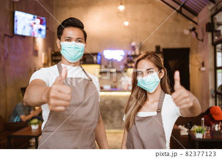 Waitress wearing a face mask at the coffee shop Waitress wearing a face mask at the coffee shop 82377123