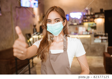 Waitress wearing a face mask at the coffee shop Waitress wearing a face mask at the coffee shop 82377125