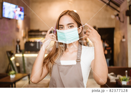 Waitress wearing a face mask at the coffee shop Waitress wearing a face mask at the coffee shop 82377128