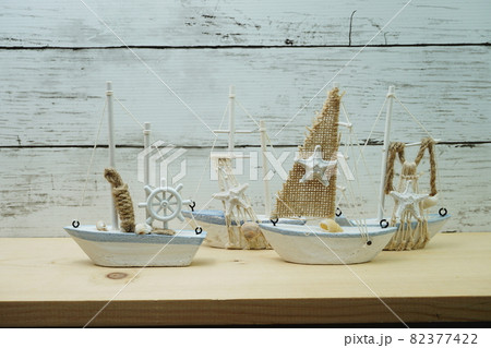Nautical background with Sailboat Model on wooden background Nautical background with Sailboat Model on wooden background 82377422