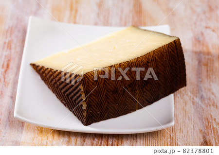 Delicious semi-hard cheese on wooden table 82378801