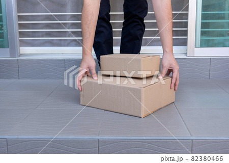 E-commerce concept a man leaving home and lifting the boxes for sending them to his customers via tracking express 82380466