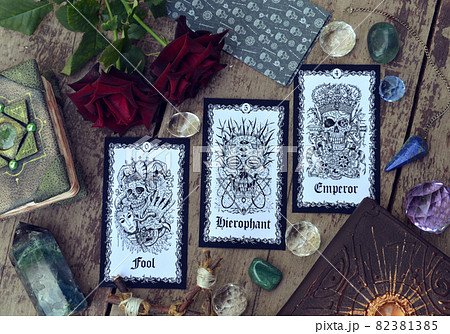 Fortune telling ritual with tarot cards, roses and crystals on witch table. Esoteric, gothic and occult background, Halloween mystic concept. Fortune telling ritual with tarot cards, roses and crystals on witch table. Esoteric, gothic and occult background, Halloween mystic concept. 82381385