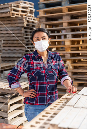 Portrait of woman worker in mask posing at warehouse Portrait of woman worker in mask posing at warehouse 82382288