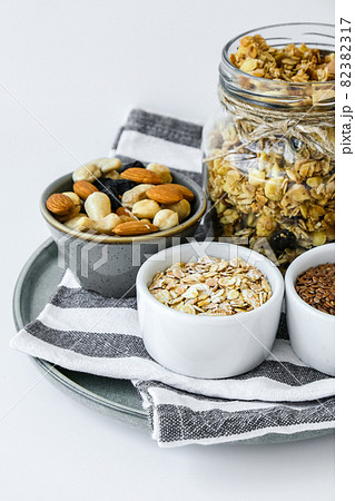 Healthy breakfast. Oatmeal Granola with greek yogurt and nuts banana muesli in jars on light background. Vegan, vegetarian and weight loss diet concept. Detox menu. Healthy breakfast. Oatmeal Granola with greek yogurt and nuts banana muesli in jars on light background. Vegan, vegetarian and weight loss diet concept. Detox menu. 82382317