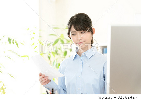 書類を見て悩む女性 82382427