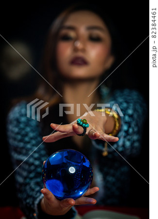 Blurred Asian witch telling fortune by crystal ball Blurred Asian witch telling fortune by crystal ball 82384461