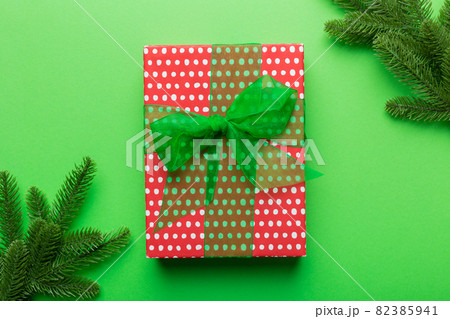 Christmas composition. Christmas gift and fir branches on cement background. Flat lay, top view, copy space 82385941