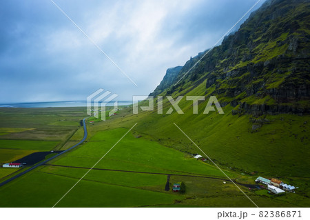 Aerial view of icelandic south coast on ring road. Landscape in Iceland at the day time. View from drone. Summer. Cloudy weather. Fresh grass on field. Travel and vacation image Aerial view of icelandic south coast on ring road. Landscape in Iceland at the day time. View from drone. Summer. Cloudy weather. Fresh grass on field. Travel and vacation image 82386871