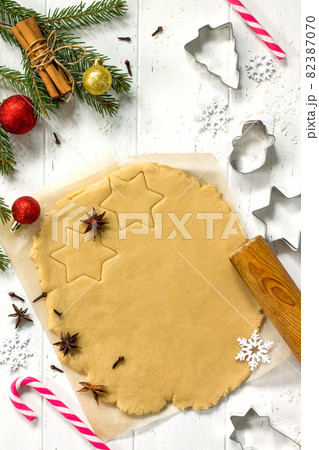 Christmas cookies. Ginger dough for gingerbread, star, Christmas tree, spices (cinnamon, cloves and anise), flour in the home kitchen white wooden table. Top view. Copy space. Christmas cookies. Ginger dough for gingerbread, star, Christmas tree, spices (cinnamon, cloves and anise), flour in the home kitchen white wooden table. Top view. Copy space. 82387070