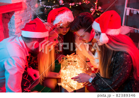 Party and celebration. Winter holiday and xmas. Garland on jar as decoration. Young people and garland. 82389346