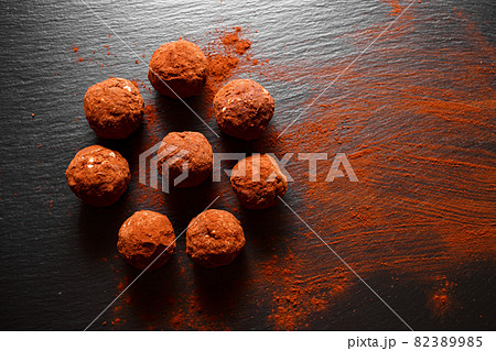 Chocolate homemade candy truffles laying on the slate background. Homemade cooking background with copy space 82389985