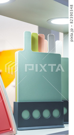 Various plastic cutting boards are stored on a stand on the table. Kitchen utensils and accessories in trendy pastel colors Various plastic cutting boards are stored on a stand on the table. Kitchen utensils and accessories in trendy pastel colors 82390348
