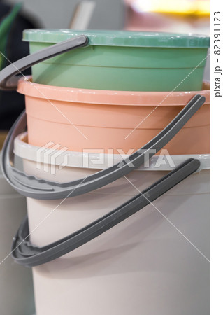Various plastic new empty buckets stacked. Inventory and household items in trendy pastel colors. Industrial background 82391123