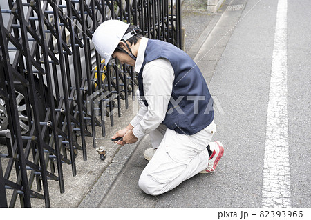 駐車場の伸縮ゲートの点検をする作業員 82393966