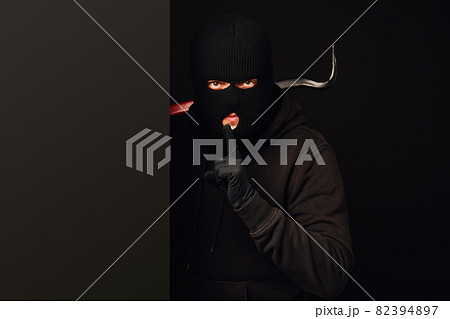 Robber making silence gesture on black 82394897