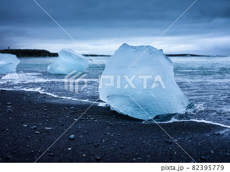 Diamond beach, Iceland. Ice on black sand on the beach. Ocean bay and icebergs. 82395779