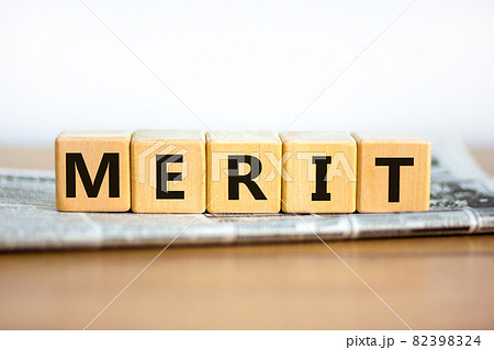 Merit symbol. Wooden cubes with the word 'merit'. Beautiful white background, copy space. Newspaper. Business and merit concept. Merit symbol. Wooden cubes with the word 'merit'. Beautiful white background, copy space. Newspaper. Business and merit concept. 82398324
