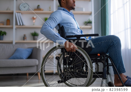 Unrecognizable paraplegic black guy in wheelchair suffering from depression at home, closeup Unrecognizable paraplegic black guy in wheelchair suffering from depression at home, closeup 82398599