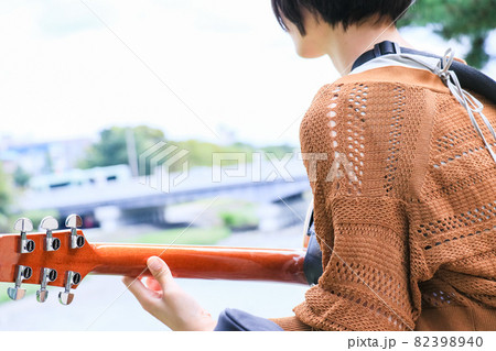 アコースティックギターを弾くショートヘアの女の子の写真素材 3940