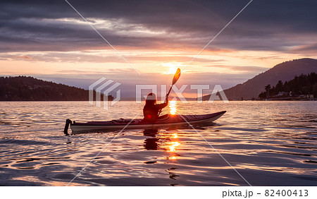 Adventurous Woman on Sea Kayak paddling in the Pacific Ocean. Adventurous Woman on Sea Kayak paddling in the Pacific Ocean. 82400413