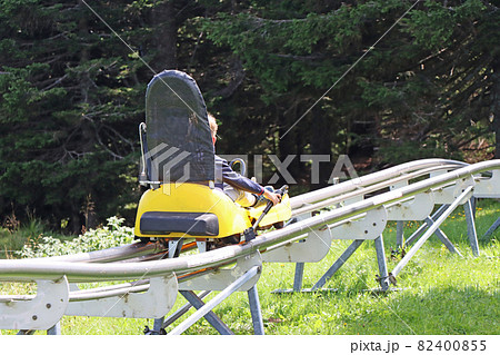 Little boy enjoying a summer fun roller alpine coaster ride 82400855