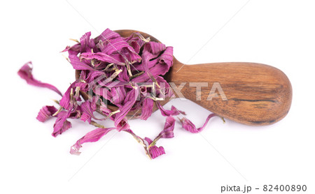 Dried Echinacea flowers in wooden spoon, isolated on white background. Petals of Echinacea purpurea. Medicinal herbs. 82400890