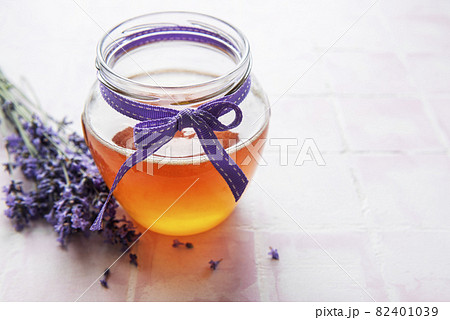 Jar with honey and fresh lavender flowers 82401039
