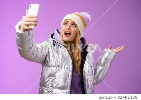 Upset bothered whining blond girl complaining cannot find right angle take selfie with cool sightseeing during vacation travelling abroad yelling smartphone pointing aside, purple background 82401129