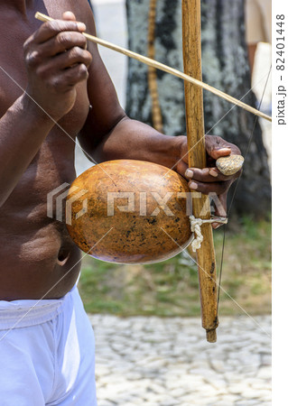Musician playing a traditional Brazilian percussion instrument called berimbau during a capoeira performance Musician playing a traditional Brazilian percussion instrument called berimbau during a capoeira performance 82401448