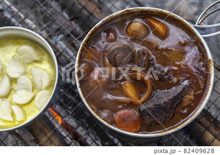キャンプのご飯づくり（ビーフシチューとニンニクの素揚げ） 82409628